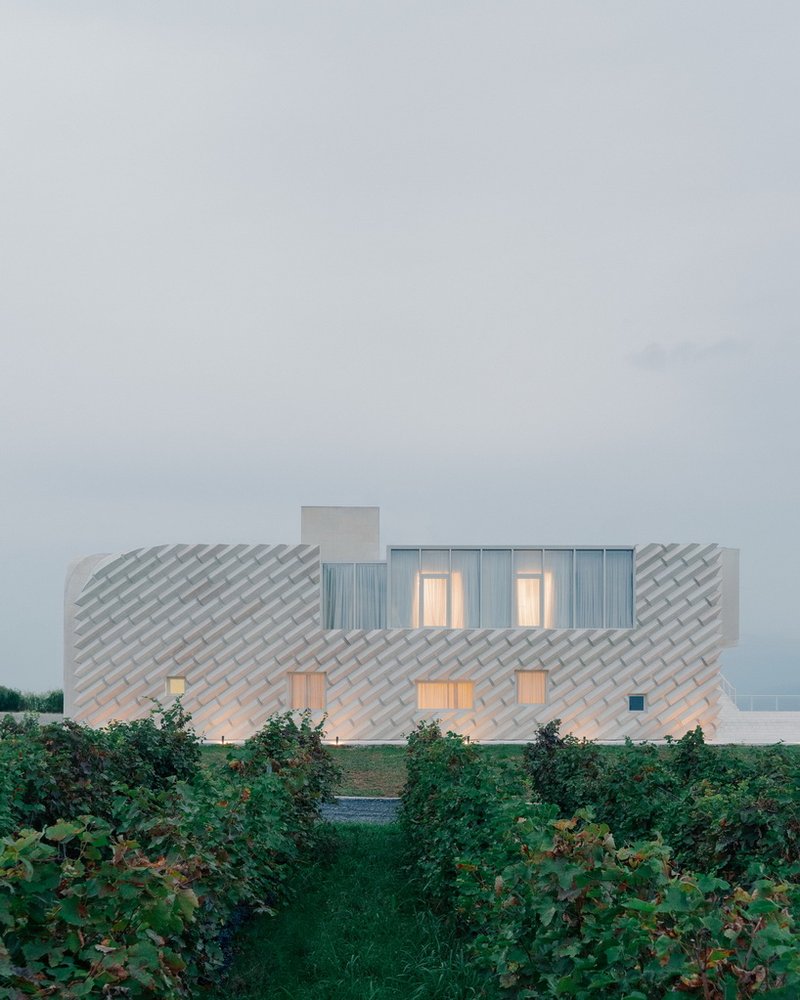 arches and voids carve winery’s monolithic white facade in georgia