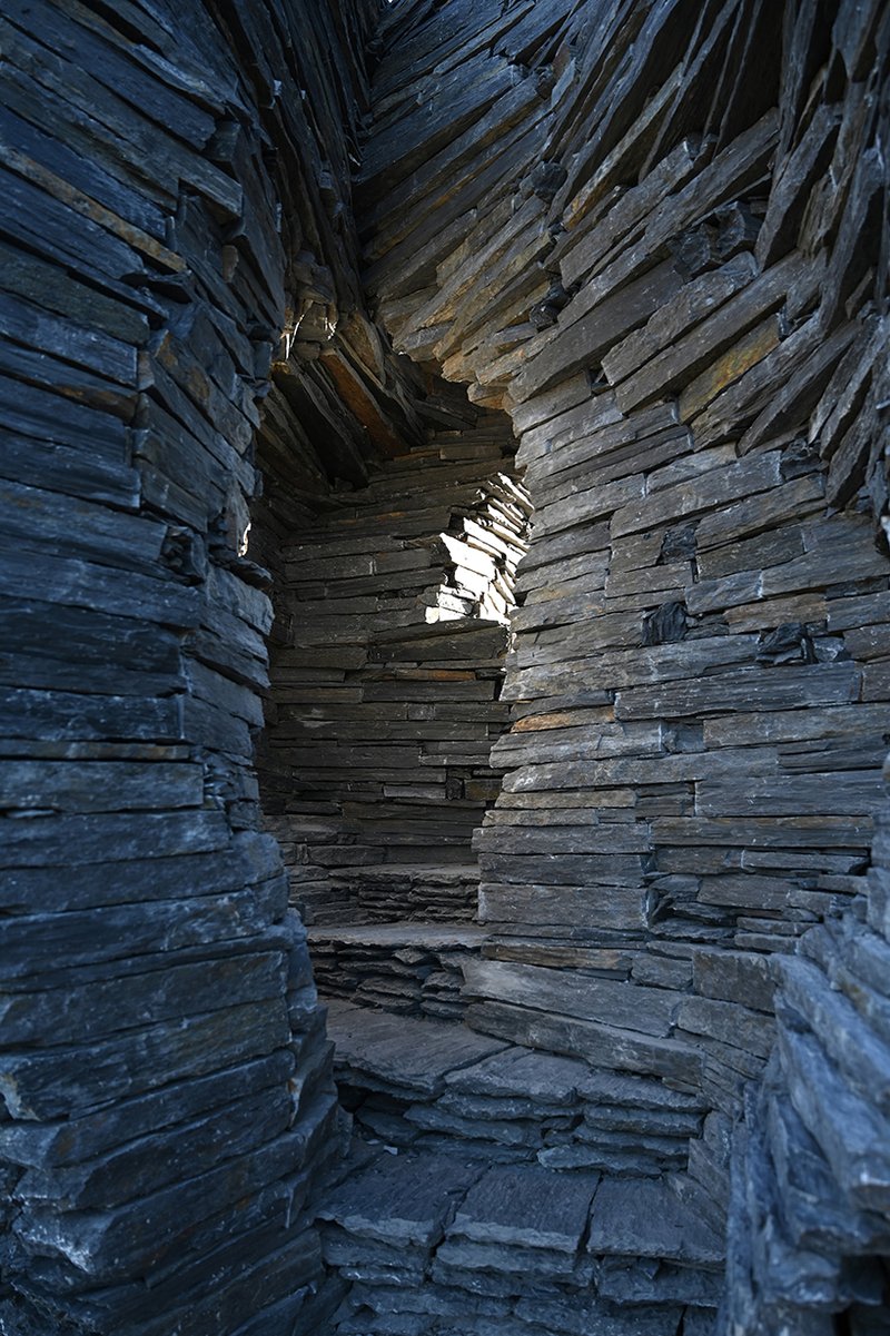 atelier yokyok sculpts sphere land installation out of black schist and granite in portugal